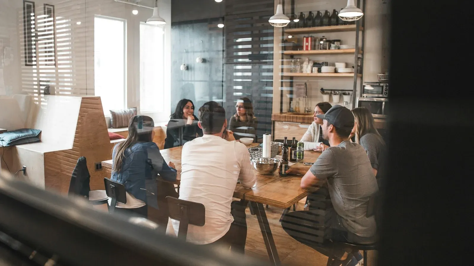 Colleagues discussing work around a table in a bright office
