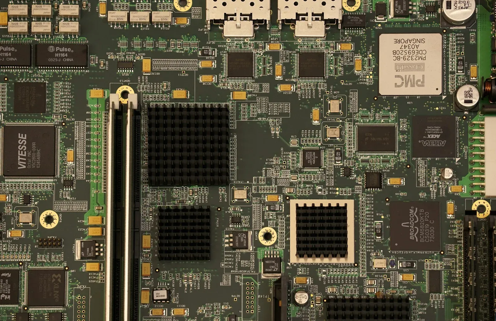 Close-up of chips, connectors and traces on a green computer motherboard