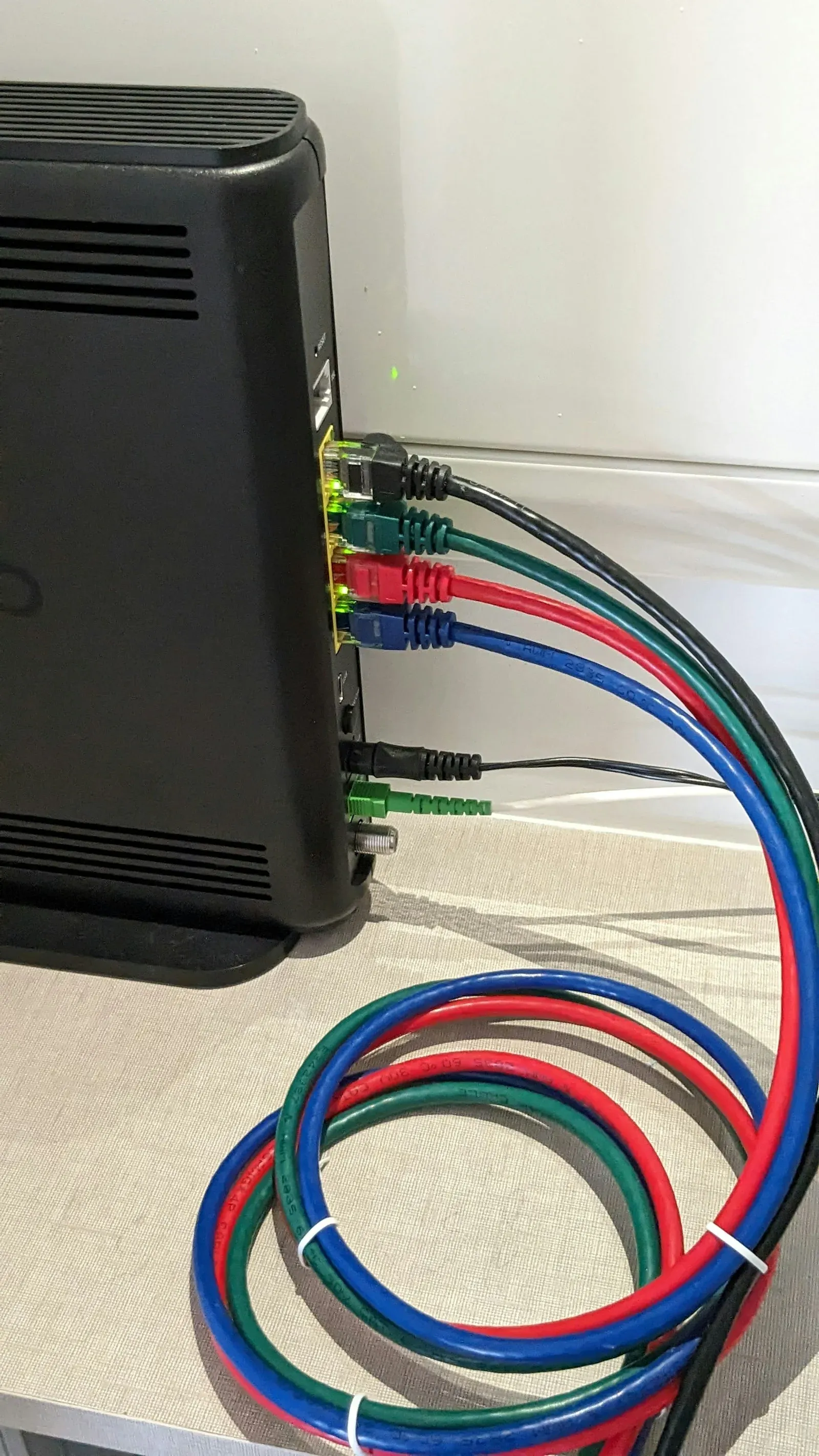 Coloured network cables plugged into the back of a router