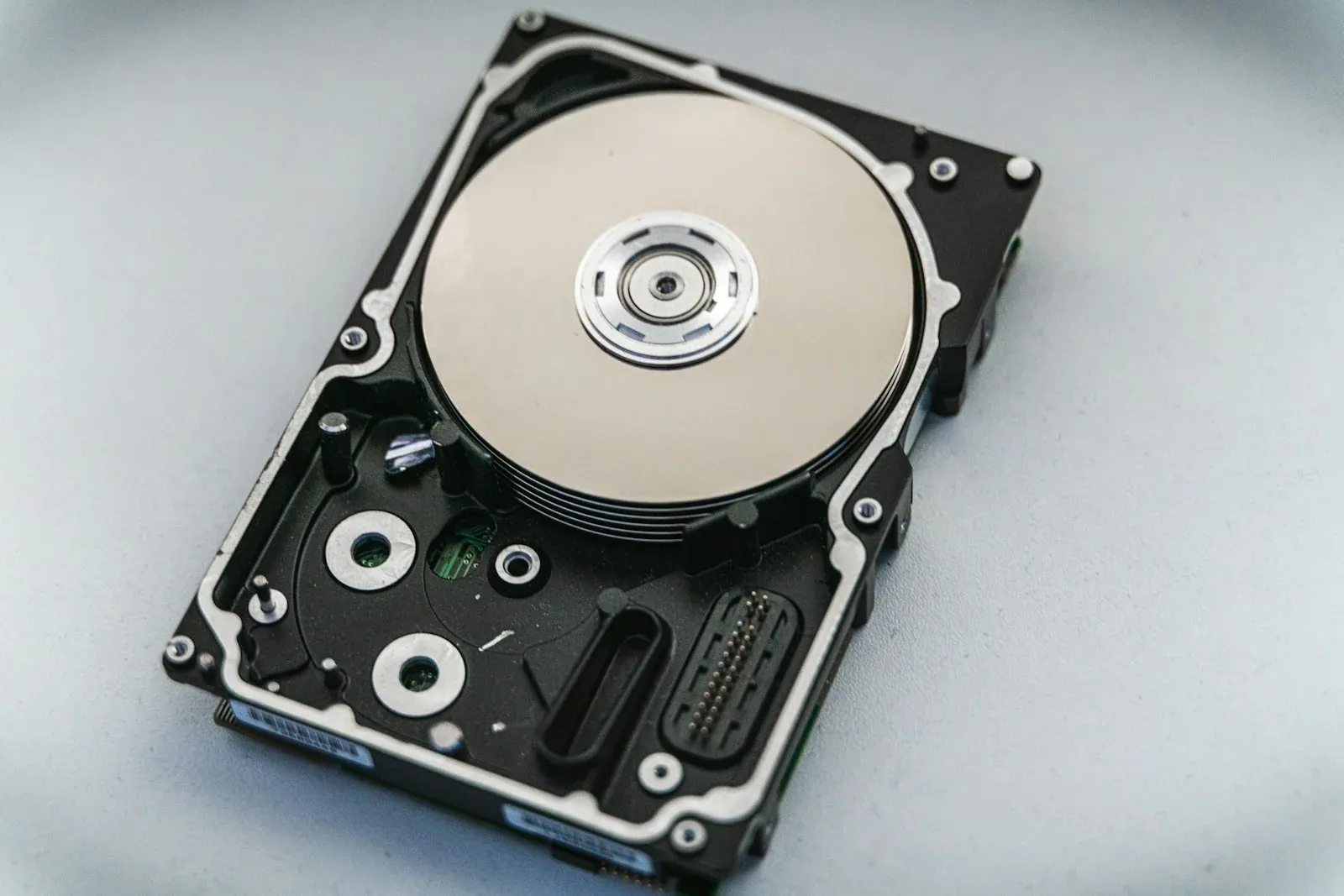 An open hard drive showing its circular platter and read head