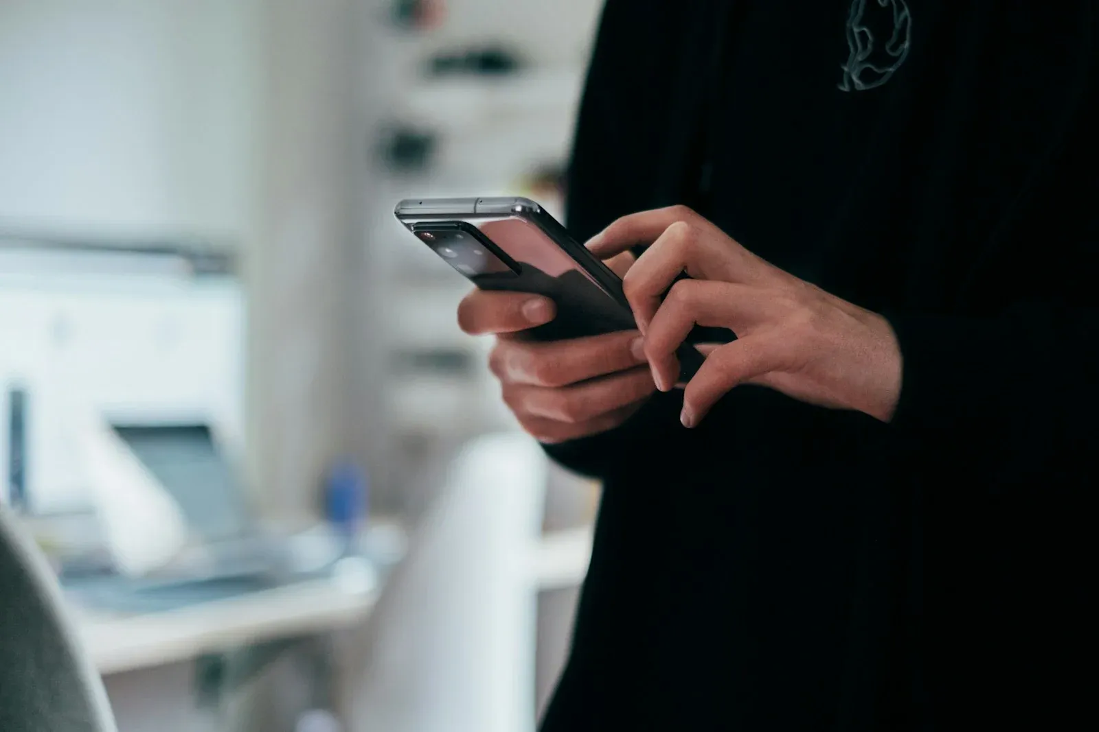 Hands holding a smartphone in a softly lit room